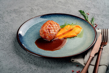 A dish of juicy grilled duck fillet steak with carrot or pumpkin