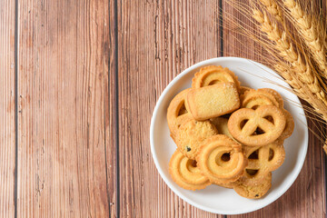 Five whole pretzel, round and rectangular shortbread biscuits with sugar on wood background.