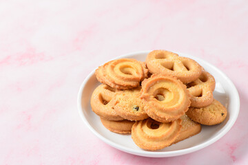 Set of danish butter cookies macro cutout. Five whole pretzel, round and rectangular shortbread biscuits with sugar on pink background.