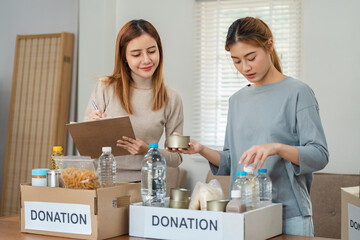 Women Organizing Food Donations in Boxes for Charity - volunteer and Community Support Concept with...