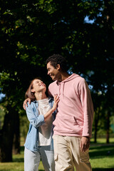 A diverse couple, dressed vibrantly, strolling through a peaceful park, enjoying each others company.
