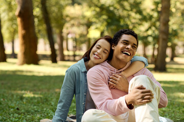 A man and a woman are sitting on the grass in a park, dressed in vibrant attires, embracing each other in a moment of serenity.