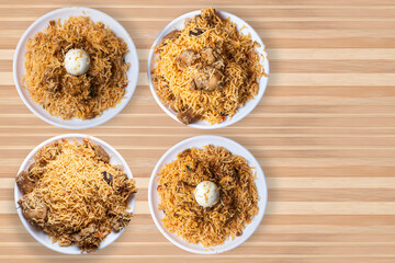 Set of popular biryani dishes on white plate on wooden table background.