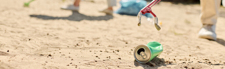 A refreshing can of soda resting on sandy beach under the suns warm glow while diverse couple...