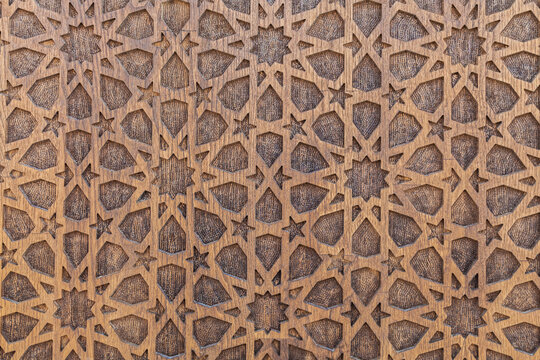 Arabic Uzbek Islamic patterns ornament with stars on a wooden carved door in Uzbekistan in Tashkent close-up as a background