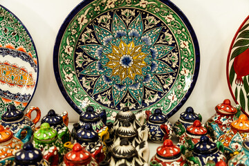 Traditional ceramics of Central Asia. Ancient traditional Uzbek ceramic dishes with national ornaments. Colorful handmade ceramics from Uzbekistan.