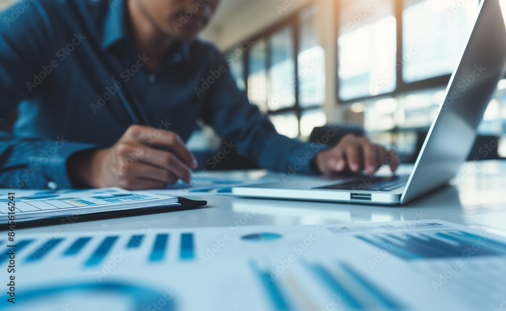 Poster a person working on financial documents with charts and graphs on a desk, emphasizing analysis and b