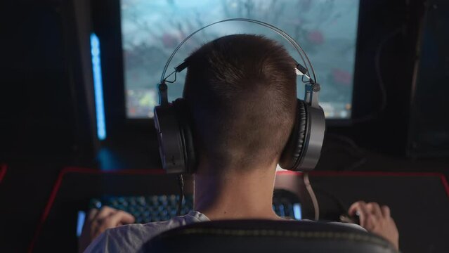 E-sport tournament Gamer in headset plays video game on PC Computer club, real-time strategy RTS multiplayer online battle competition. Skill. Gaming earphones. Professional cyber sport championship
