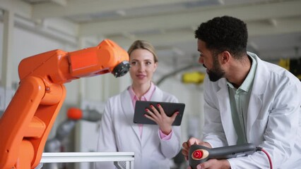 Robotic engineers working on new project, holding remote control of robotic arms, controlling its actions. Concept of robotics, engineering and computer science. - Powered by Adobe