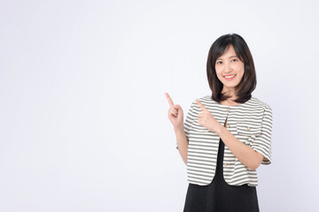 A Young asian woman pointing finger to free copy space isolated on white studio background