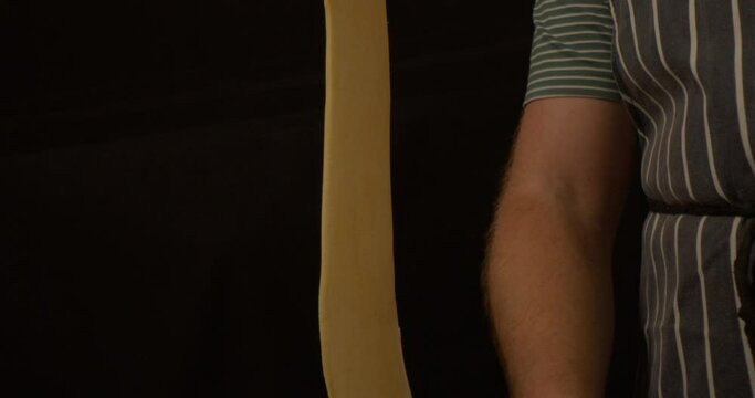 Male hand making lasagne sheets in a pasta machine