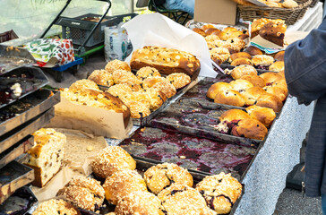 Freshly baked sweet buns with a crumbly topping and fruity filling, in metal trays
