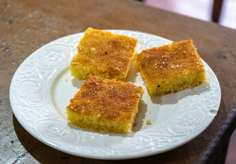 Moroccan lemon cake meskouta square slices on white plate. Traditional Moroccan dessert