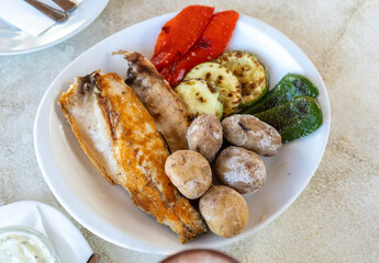 Papas arrugadas sea water boiled potatoes, grilled fish and vegetables, red mojo, green mojo, dining table