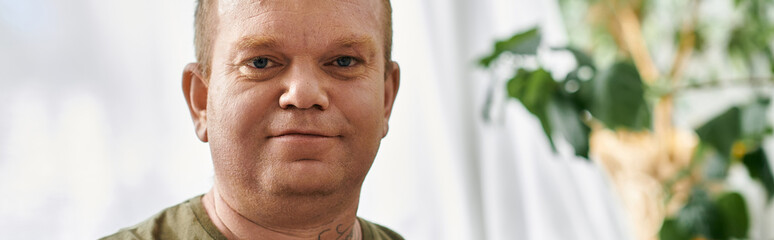 A man with inclusivity in casual attire, sitting comfortably indoors.
