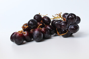 Dark purple grape with stem, isolated on white background