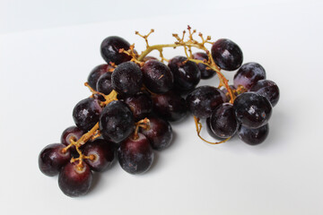 Dark purple grape with stem, isolated on white background