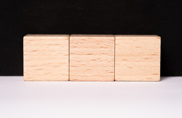 Three empty wooden cubes with place for letters