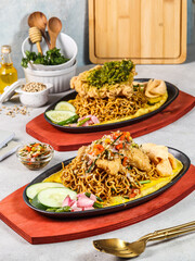 several foods such as seafood and noodles on the hotplate