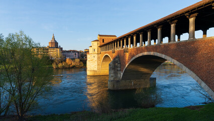 Fototapeta premium Landscape of Ponte Coperto (covered bridge) and Duomo di Pavia (Pavia Cathedral) in Pavia at sunny day, Lombardy, italy.