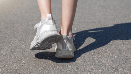 close up of child legs walking away from camera in the road