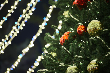 New Year christmas tree decorated Christmas balls with yellow flickering lights of garlands copy...