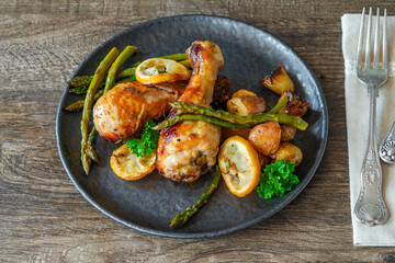 Lemon chicken drimsticks with baked potatoes and asparagus