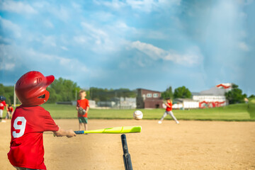 View from behind home plate with a batter swinging at a T-ball.