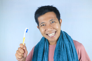 Funny face expression smiling asian men holding toothbrush, isolated over white background