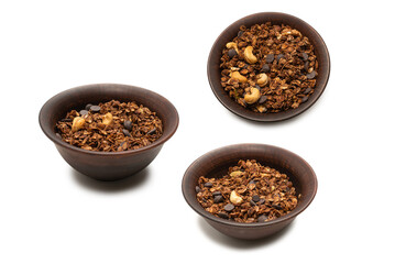 Chocolate granola cereal with nuts in a bowl background.