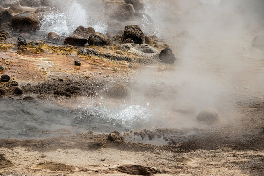 Alolabad geothermal area in Ethiopia with surreal landscape of colorful hot springs, steaming fumaroles, and erupting salt geysers in an arid, remote desert setting below sea level, Afar desert