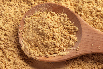 Peanut flour in a wooden spoon. Culinary fine golden nut powder is a versatile ingredient