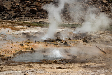 Alolabad geothermal area in Ethiopia with surreal landscape of colorful hot springs, steaming fumaroles, and erupting salt geysers in an arid, remote desert setting below sea level, Afar desert