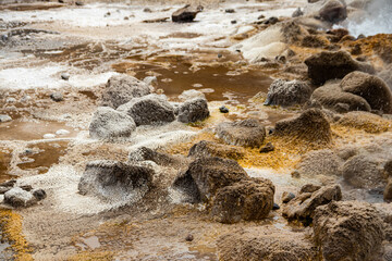 Alolabad geothermal area in Ethiopia with surreal landscape of colorful hot springs, steaming fumaroles, and erupting salt geysers in an arid, remote desert setting below sea level, Afar desert.