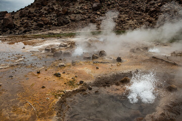 Alolabad geothermal area in Ethiopia with surreal landscape of colorful hot springs, steaming fumaroles, and erupting salt geysers in an arid, remote desert setting below sea level, Afar desert