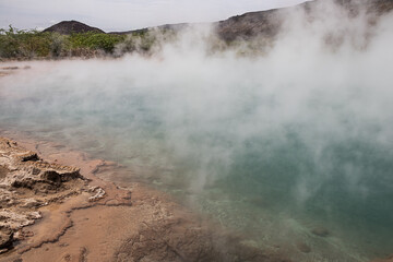 Alolabad geothermal area in Ethiopia with surreal landscape of colorful hot springs, steaming fumaroles, and erupting salt geysers in an arid, remote desert setting below sea level, Afar desert.