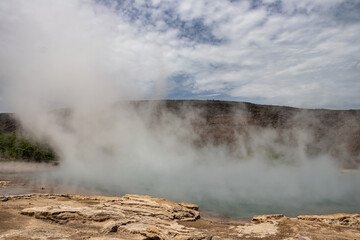 Alolabad geothermal area in Ethiopia with surreal landscape of colorful hot springs, steaming fumaroles, and erupting salt geysers in an arid, remote desert setting below sea level, Afar desert. 