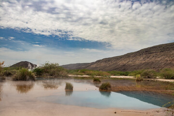 Alolabad geothermal area in Ethiopia with surreal landscape of colorful hot springs, steaming fumaroles, and erupting salt geysers in an arid, remote desert setting below sea level, Afar desert
