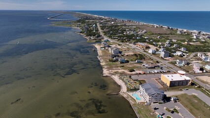 Drone view looking North with homes, business and traffic below and bridge in distance at Cape...