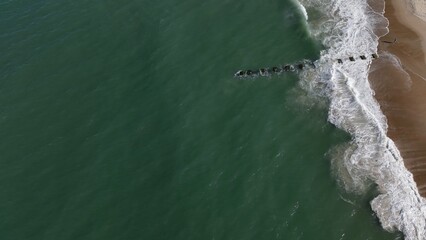 Aerial view of coastline with ocean waves breaking on beach in Outer Banks, North Carolina at Nags...