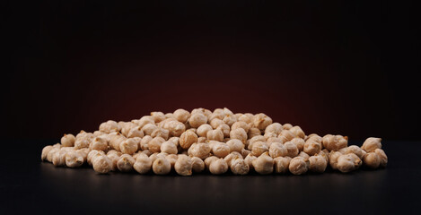 Heap of chickpeas on a dark background.