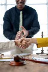 A man shakes hands with a woman in a yellow jacket
