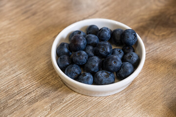 blueberries in bowl on wooden floor