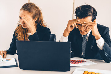 Unhappy serious businessman and businesswoman working using laptop computer on the office desk. Bad...