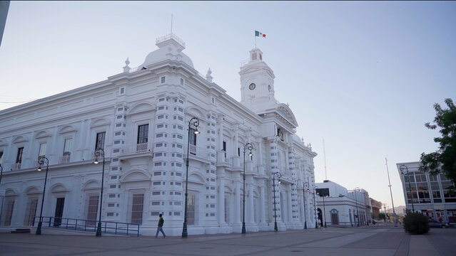 White building in the north of Mexico at morning, the wind is blowing and move a Mexican Flag