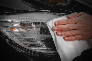 Polishing car headlights on a car.
