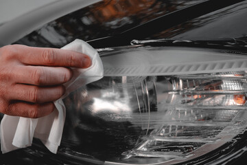 Polishing car headlights on a car.
