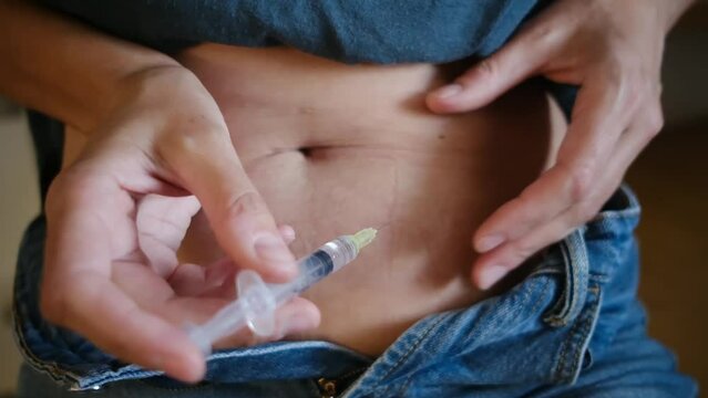 A woman injecting hormones into her stomach at home, illustrating hormone therapy and in vitro fertilization (IVF) treatment