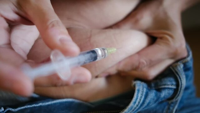 Woman injecting progesterone into her belly for fertility treatment, focusing on assisted reproduction, gynecology, and reproduction