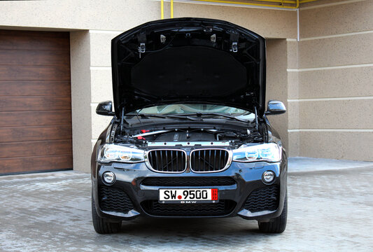 Vinnytsia, Ukraine; May 04, 2024. Black BMW X4 M40i open hood. German SUV BMW X4 gas engine. Broken engine BMW X4 with the hood up. Front view.